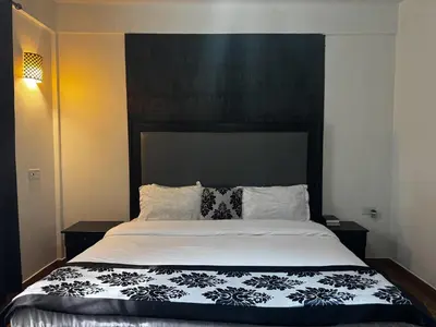 a bedroom with a bed with a black and white comforter at Njiro Climax in Arusha