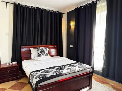 a bedroom with a bed with black drapes at Njiro Climax in Arusha