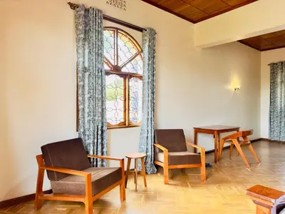 a room with chairs and a window and a table at Starehe Villa in Arusha