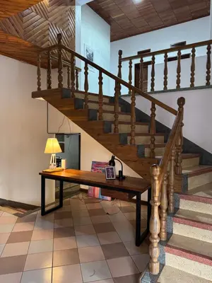 a living room with a wooden table and stairs at Starehe Villa in Arusha