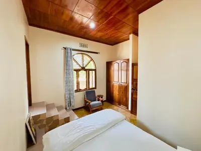a bedroom with a bed and a chair in it at Starehe Villa in Arusha