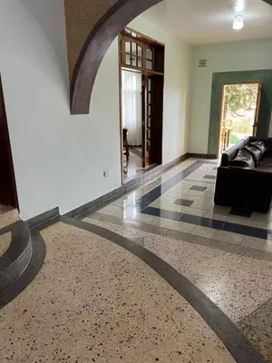 a living room with a couch and a tile floor at Starehe Villa in Arusha