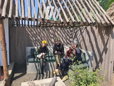 a group of three people sitting on a bench at freedom inn in Arusha