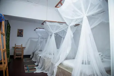 a room with white mosquito nets hanging from the ceiling at freedom inn in Arusha