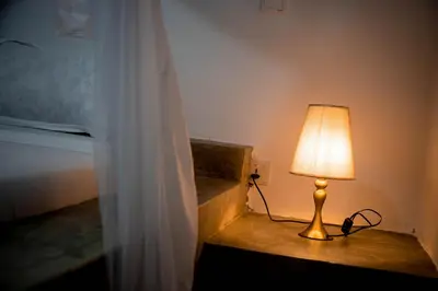 a lamp sitting on a table next to a bed at freedom inn in Arusha