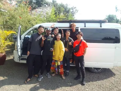 a group of people standing in front of a van at freedom inn in Arusha