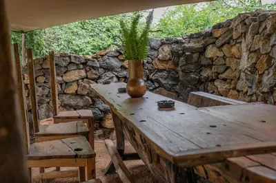 a wooden table with a plant on top of a stone wall at Dolly Farm & River Camp, Luxury Tents in Usa River