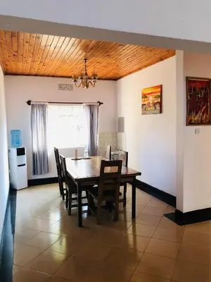 a dining room with a table and chairs at COZY NYUMBA in Arusha
