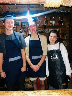 a group of three people standing in a kitchen at Meleji House in Arusha