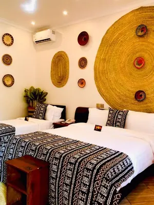 a bedroom with two beds and a wall with plates at Kerama Silent Lodge in Arusha