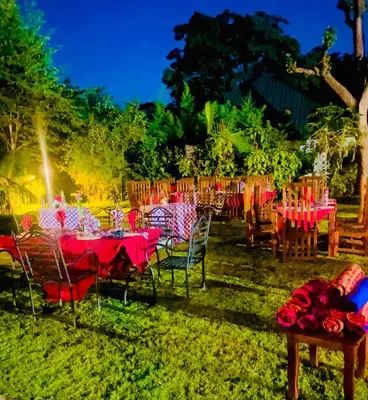 a group of tables and chairs with red table cloth at Kerama Silent Lodge in Arusha
