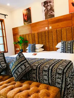 a bedroom with a large bed with a wooden headboard at Kerama Silent Lodge in Arusha
