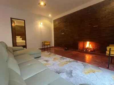 a living room with a couch and a fireplace at Kerama Silent Lodge in Arusha