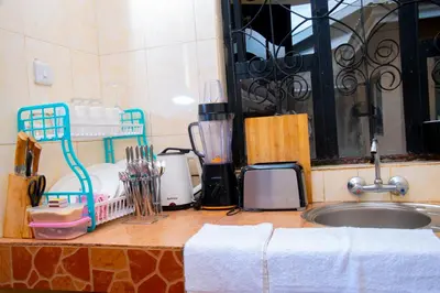 a kitchen counter with a sink and a counter top with towels at Mella home Arusha in Arusha