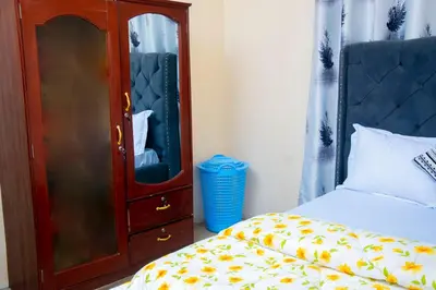 a bedroom with a dresser and a bed and a cabinet at Mella home Arusha in Arusha