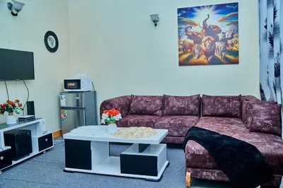 a living room with a purple couch and a table at Mella home Arusha in Marombosa