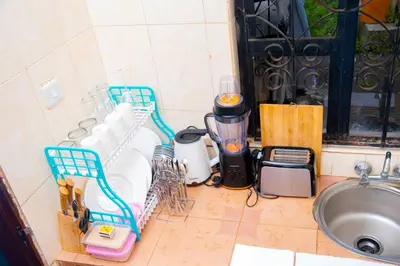 a kitchen counter with a blender and a sink at Mella home Arusha in Marombosa