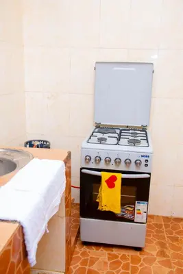 a kitchen with a stove with a towel on the door at Mella home Arusha in Marombosa