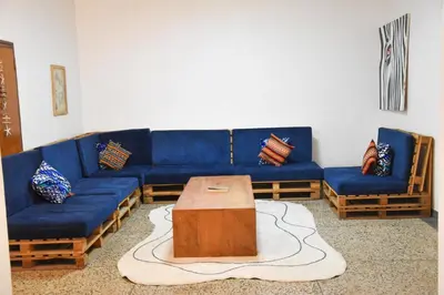 a living room with a blue couch and a table at Karibu Africa Home in Moshi