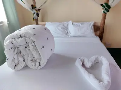 a bed with a heart made out of towels at Hill View Garden Hotel in Moshi