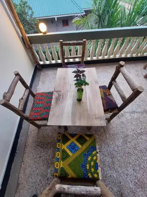 a wooden table with a potted plant on a balcony at Hill View Garden Hotel in Moshi