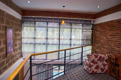 a balcony with a chair and a window at Jabulani Private Villas in Arusha
