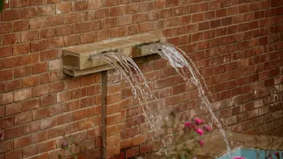 a water fountain attached to a brick wall at Jabulani Private Villas in Arusha