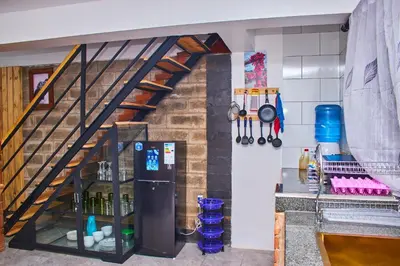 a kitchen with a staircase and a refrigerator in a room at Jabulani Private Villas in Arusha