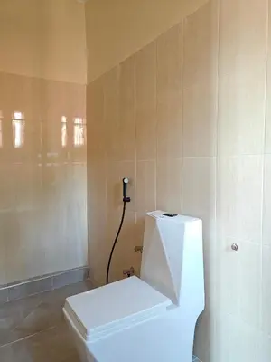 a bathroom with a white toilet in a room at Hostel Kiliwood in Moshi