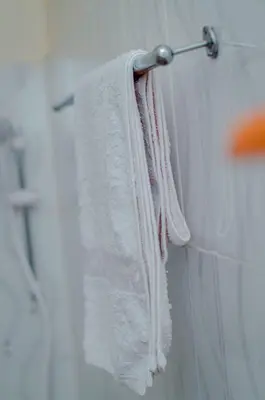 a group of towels hanging on a towel rack in a bathroom at Hostel Kiliwood in Moshi