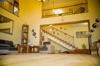 a living room with a staircase in a house at Cornerstone Villas in Arusha