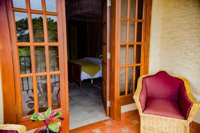 a room with a chair and an open door at Cornerstone Villas in Arusha