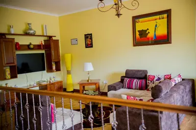 a living room with a couch and a tv at Cornerstone Villas in Arusha