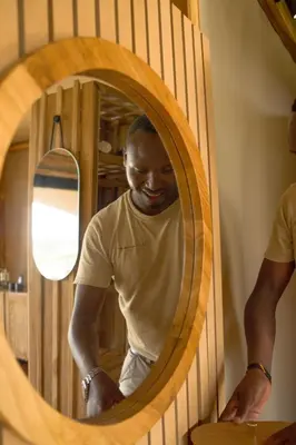 a man is standing in front of a mirror at Anantya Serengeti in Serengeti