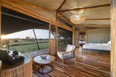 a bedroom in a tent with a bed and a table at Anantya Serengeti in Serengeti