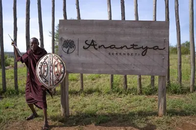 a man standing in front of a sign at Anantya Serengeti in Serengeti