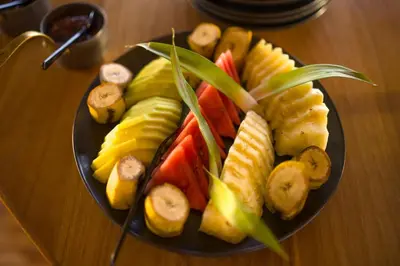 a plate of fruit on a wooden table at Anantya Serengeti in Serengeti