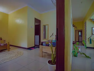 a bedroom with a bed in a room with yellow walls at Home Feeling Kilimanjaro in Moshi