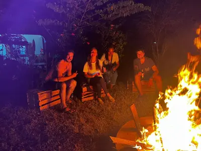a group of people sitting around a fire at Home Feeling Kilimanjaro in Moshi