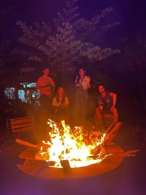 a group of people sitting around a large fire at Home Feeling Kilimanjaro in Moshi