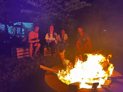a group of people sitting around a fire at Home Feeling Kilimanjaro in Moshi