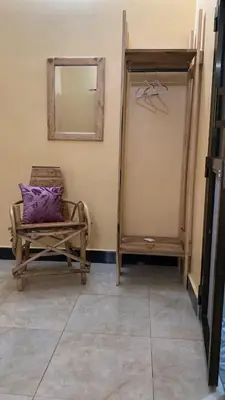 a chair with a purple pillow sitting in a room at Home Feeling Kilimanjaro in Moshi
