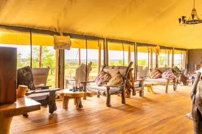 a room with couches and tables in a tent at Serengeti Malaika Luxury Camp in Serengeti National Park