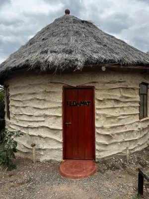 a hut with a thatch roof with a door at Maasai Eco Boma & Lodge - Experience Maasai Culture in Makuyuni