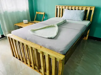 a bed with a wooden frame in a room at Karibu Eco-Hostel Arusha in Arusha