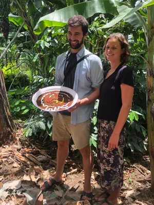 a man and a woman holding a plate of food at Karibu Eco-Hostel Arusha in Arusha