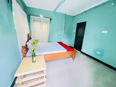 a small room with a bed and a table at Karibu Eco-Hostel Arusha in Arusha