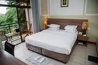 a bedroom with a large bed and a balcony at Greenside Hotel in Arusha