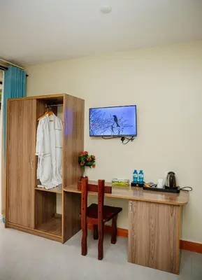 a room with a desk and a chair and a shelf at Greenside Hotel in Arusha
