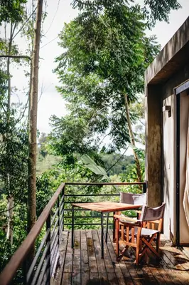 a wooden deck with a table and chairs on it at Kaliwa Lodge in Moshi